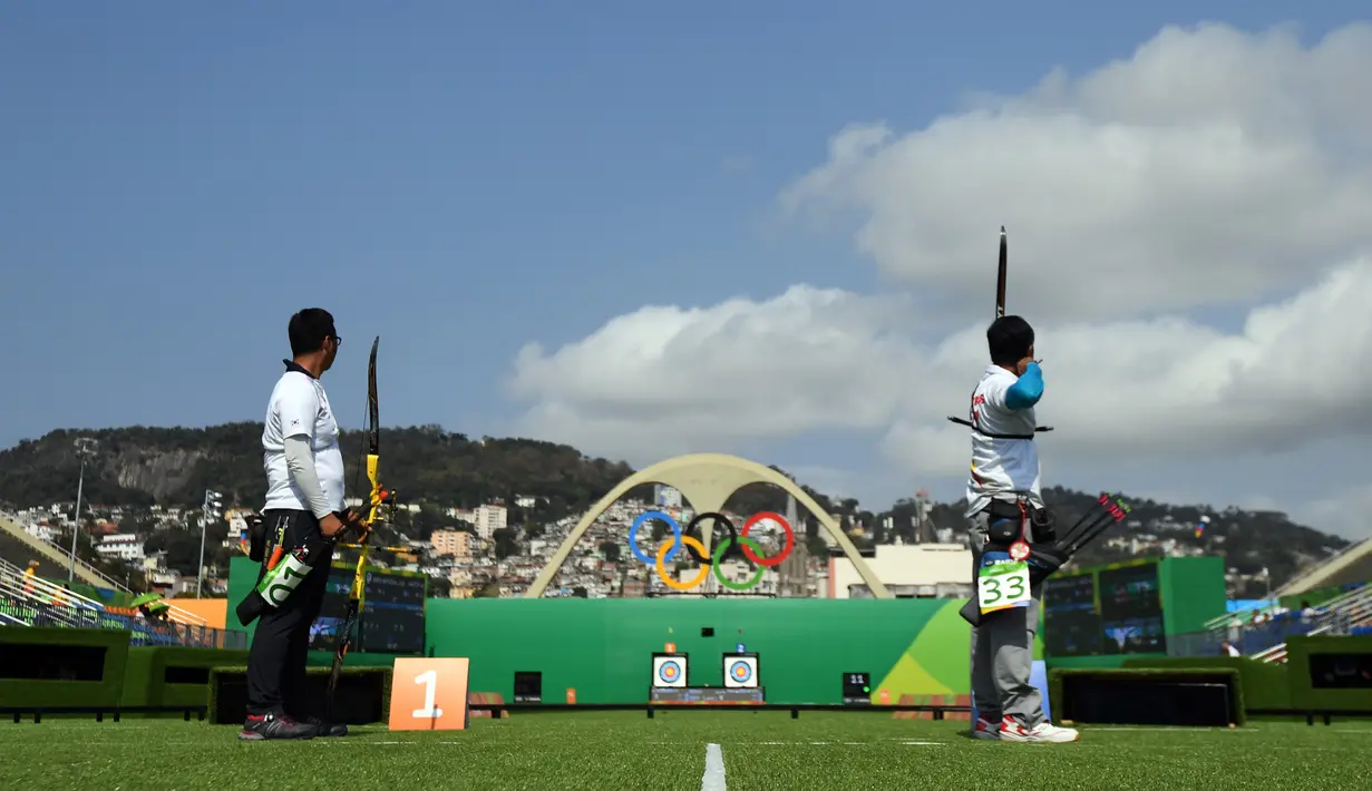 Pemanah Indonesia, Riau Ega Agatha (kanan) dan pemanah Korsel, Kim Woo-jin bersaing selama kompetisi cabang olahraga panahan Olimpiade 2016 di Rio De Janeiro, Senin (8/8). Riau Ega Agata berhasil maju ke babak 16 cabang panahan. (Jewel SAMAD/AFP)