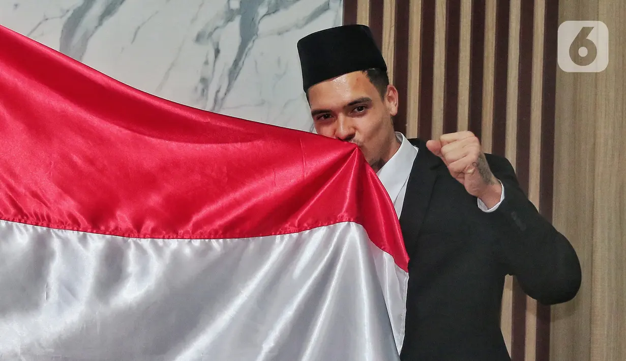 Pemain naturalisasi Shayne Pattynama mencium bendera Merah Putih saat acara pengambilan sumpah menjadi Warga Negara Indonesia (WNI) di Kanwil Kemenkumham DKI Jakarta, Selasa (24/1/2023). Shayne Pattynama diproyeksikan untuk memperkuat Timnas Indonesia pada Piala Asia 2023 mendatang. (Liputan6.com/Angga Yuniar)