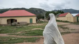 Seorang wanita berjalan di Gwoza, Nigeria timur laut, (1/8). Meskipun direbut kembali oleh pasukan Nigeria pada 2015, para ekstremis terus menyerang desa-desa terdekat di sepanjang perbatasan dengan Kamerun. (AFP Photo/Stefan Heunis)