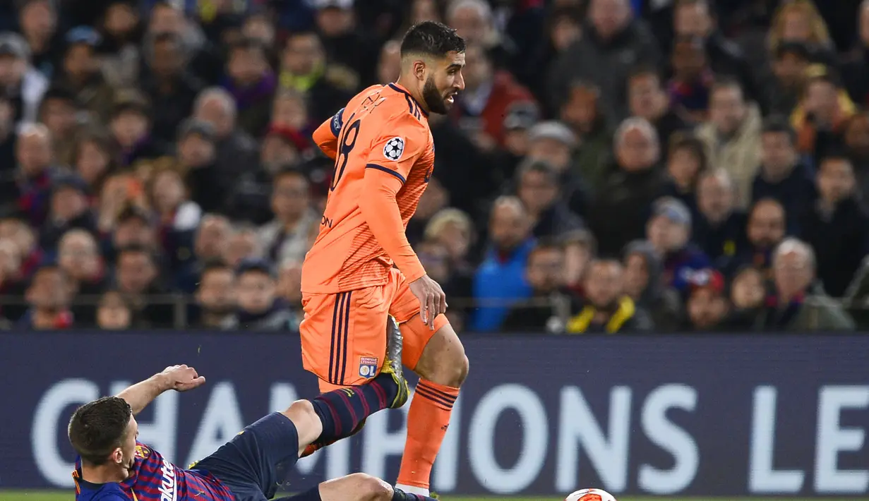 Bek Barcelona, Arthur mencoba hentikan Nabil Fekir pada leg kedua, babak 16 besar Liga Champions yang berlangsung di Stadion Camp Nou, Barcelona, Kamis (14/3). Barcelona menang 5-1 atas Lyon. (AFP/Josep Lago)