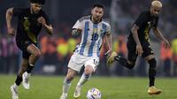 Pemain Timnas Argentina, Lionel Messi menggiring bola melewati pemain Curacao pada laga uji coba internasional yang berlangsung di Stadion Unico Madre de Ciudades, Rabu (29/3/2023) pagi WIB. La Pulga berhasil mencetak hattrick dan membawa timnya menang dengan skor 7-0. (AFP/Juan Mabromata)