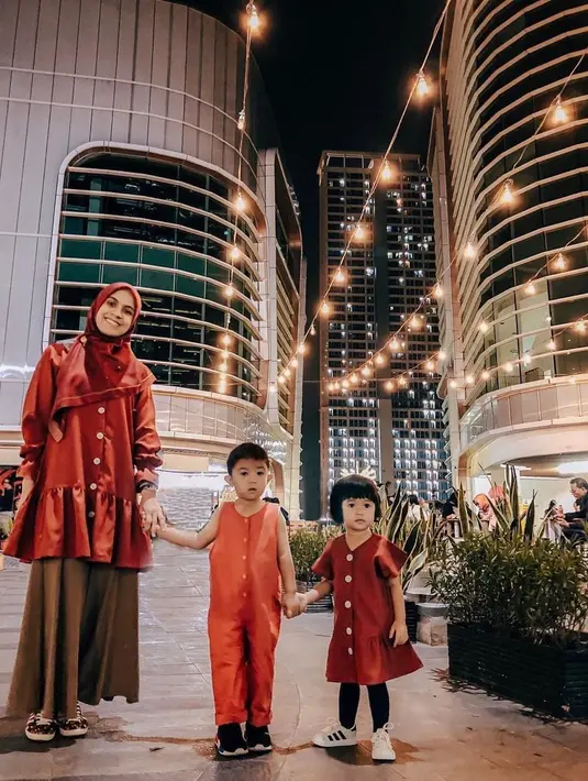 8. Outfit nuansa merah menjadi pilihan Nycta Gina dan kedua buah hatinya saat jalan-jalan di malam hari. Stylish banget! (Instagram/missnyctagina).
