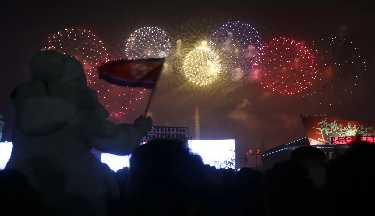 Warga menikmati pertunjukan Tahun Baru di Kim Il-sung Square, Pyongyang, Korea Utara, Sabtu (1/1/2022). Ratusan orang di Pyongyang berkumpul dengan mengenakan masker untuk menyaksikan pertunjukan kembang api menyambut Tahun Baru 2022. (AP Photo/Jon Chol Jin)