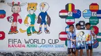 Anak-anak berpose di depan mural yang menampilkan turnamen sepak bola Piala Dunia 2026 di Polewali Mandar, Sulawesi Barat, Kamis 11 Juni 2026. (Muhammad SALIM/AFP)