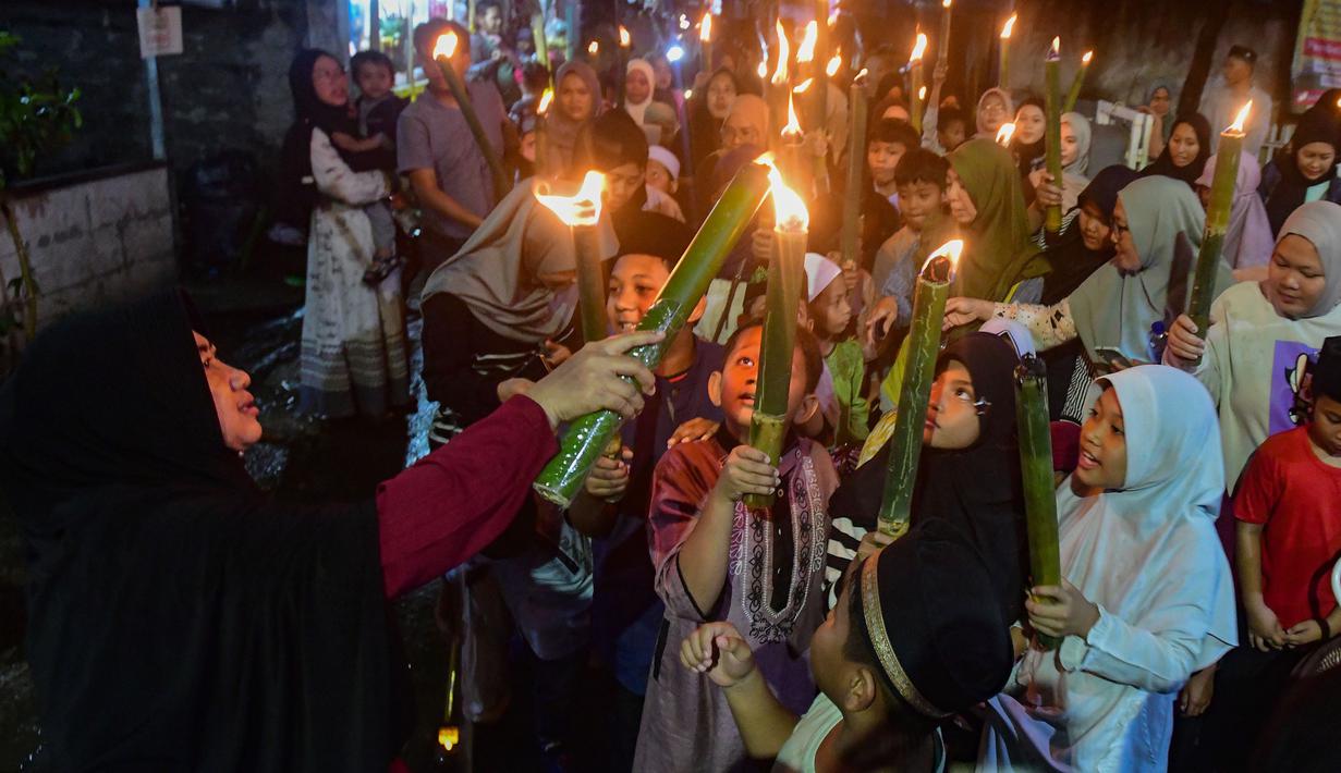Kegiatan berlangsung meriah dengan partisipasi warga sekitar yang turut mendampingi sepanjang rute pawai. Tampak dalam foto, anak-anak saat mengikuti pawai obor di kawasan Cinere,  Depok, Senin (16/2/2026). (merdeka.com/Arie Basuki)