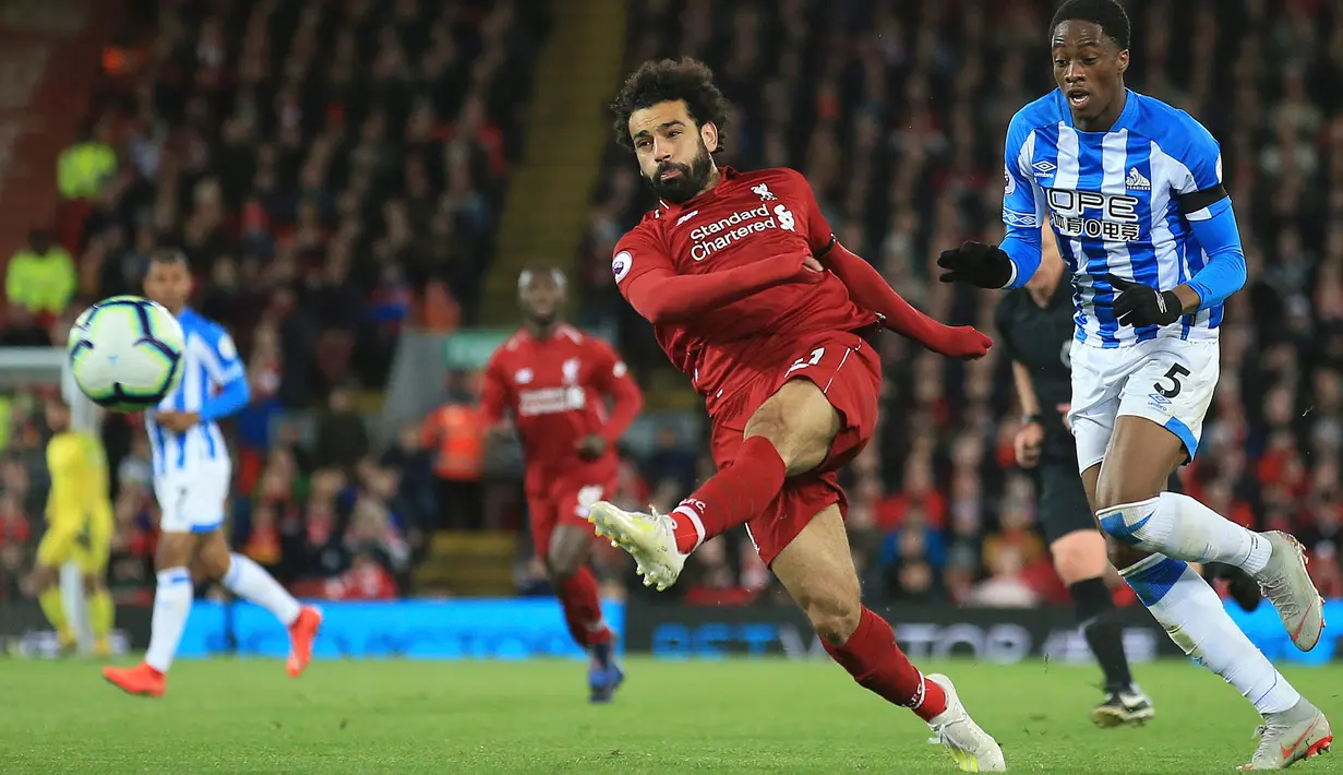 Winger Liverpool, Mohamed Salah melakukan tendangan ke arah gawang Huddersfield Town dalam laga lanjutan Premier League 2018-19 pekan ke-36 di Anfield, Jumat (26/4). Bermain di kandang sendiri, Liverpool menang dengan skor telak 5-0.  (AP Photo/Jon Super)