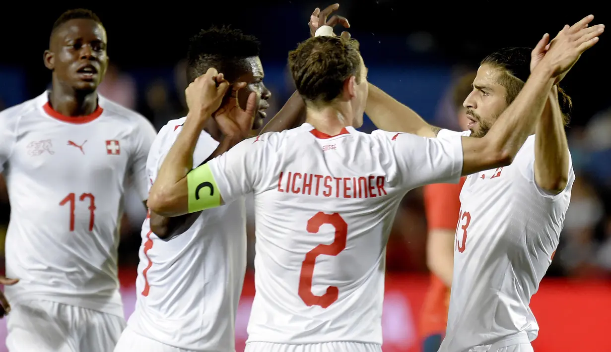 Para pemain Swiss merayakan gol yang dicetak Ricardo Rodriguez ke gawang Spanyol pada laga persahabatan di Stadion La Ceramica, Vila-real, Minggu (3/6/2018). Kedua negara bermain imbang 1-1. (AFP/Jose Jordan)