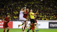 Penyerang Timnas Darren Lok (kuning) berduel di udara dengan kiper dan pemain belakang Timnas Thailand dalam laga semifinal leg pertama Piala AFF 2022, Sabtu (7/1/2023) di Stadion Bukit Jalil. (Dok. FA Malaysia)