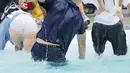 Para peserta bersaing melewati kolam sambil menggendong istrinya saat mengikuti kompetisi Wife Carrying World Championships di Sonkajarvi, Finlandia, 2 Juli 2016. Lomba unik ini digelar bulan Juli tiap tahunnya. (Timo Hartikainen/Lehtikuva/AFP)