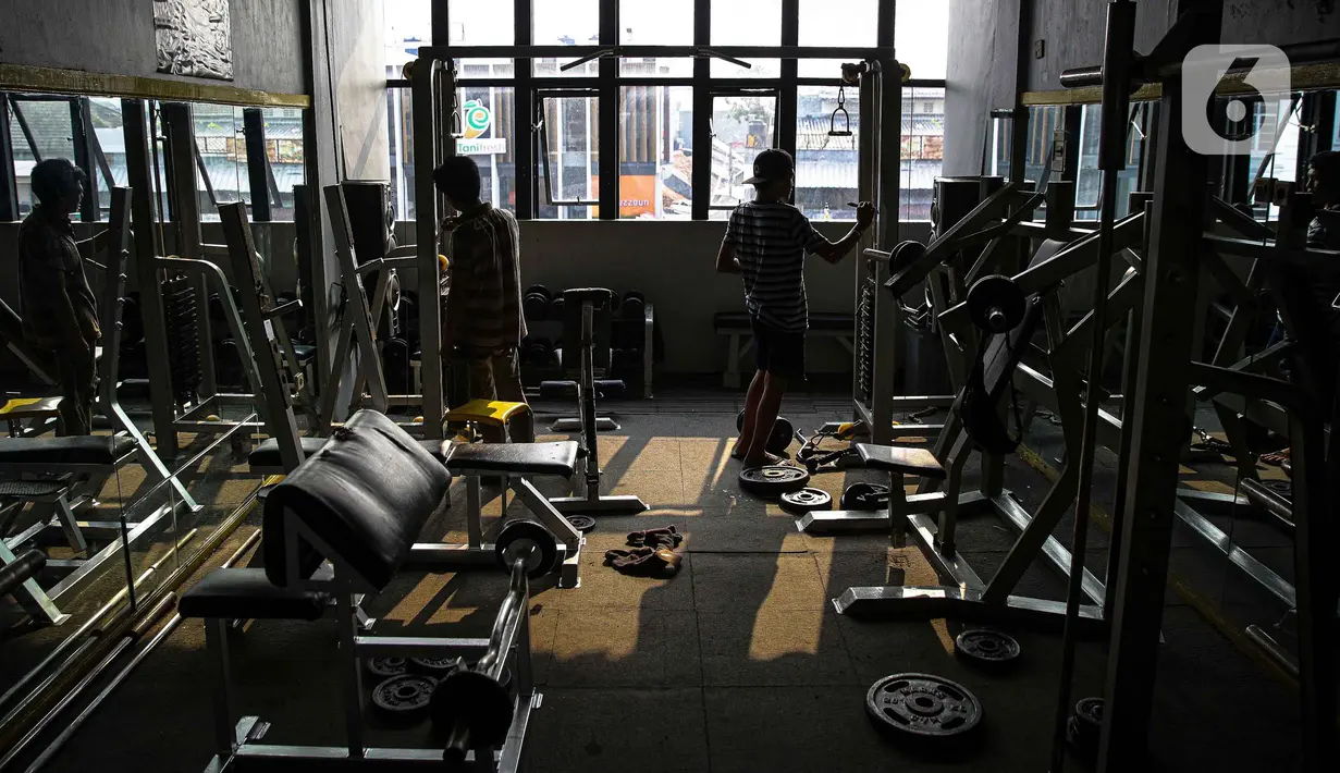 Pekerja merapikan tempat pusat kebugaran Mark Gym di kawasan Tebet, Jakarta, Selasa (5/10/2021). Meski demikian, tetap diberlakukan pembatasan seperti jumlah pengunjung maksimal 25 persen.  (Liputan6.com/Faizal Fanani)