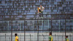 Dua orang pendukung Sriwijaya FC menyaksikan laga menghadapi Gresik United pada Piala Jenderal Sudirman di Stadion Kanjuruhan, Malang, Kamis (19/11/2015). Laga itu berlangsung sepi penonton. (Bola.com/Vitalis Yogi Trisna)