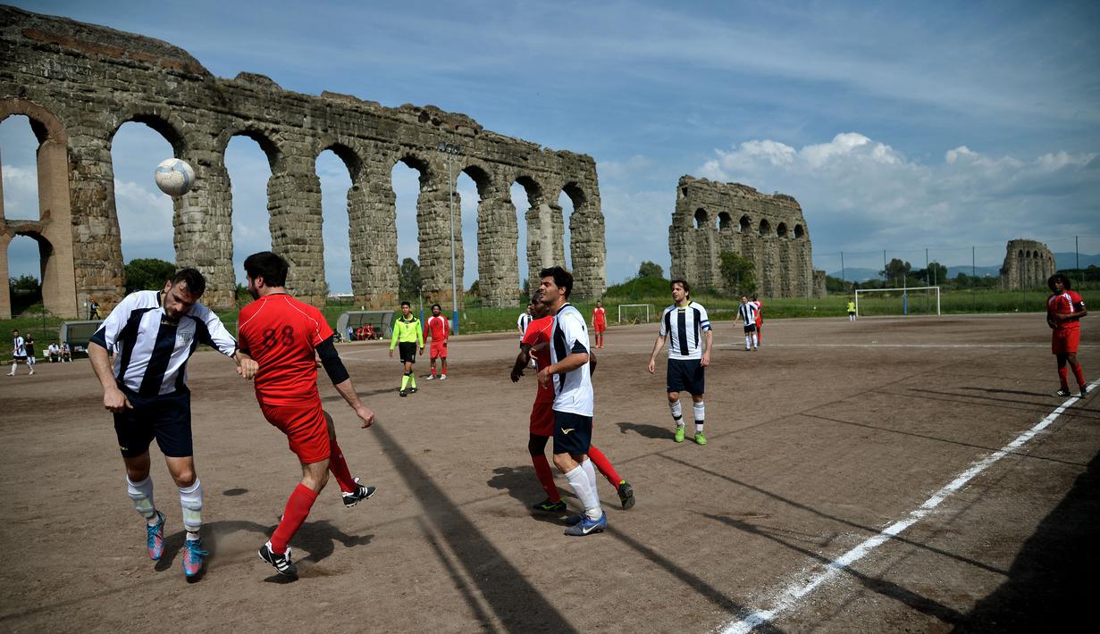 Roma terkenal akan peninggalan bangunan kuno nan megah. Salah satunya adalah Felice Aqueduct di Campo Gerini. Namun tempat yang awalnya dibangun pada tahun 1586 oleh Paus Sixtus V kini berubah menjadi arena olahraga, salah satunya yaitu lapangan sepak bola. (AFP/Filippo Monteforte)
