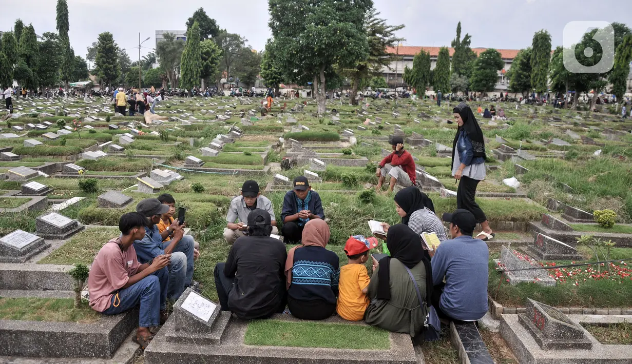 Sekelompok warga memanjatkan doa saat berziarah ke makam kerabat di TPU Kemiri. (merdeka.com/Iqbal S. Nugroho)