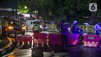Polisi berjaga saat penyekatan jalan di kawasan Pasar Baru, Jakarta, Kamis (31/12/2020). Polda Metro Jaya menutup sejumlah ruas jalan selama Car Free Night dan Crowd Free Night pada malam Tahun Baru 2021 untuk mencegah penyebaran COVID-19. (Liputan6.com/Faizal Fanani)