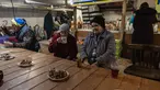 Penduduk setempat berkumpul di ruang bawah tanah di bawah pemadaman listrik di kota Bakhmut, Ukraina timur (22/12/2022). Mereka mencari perlindungan karena penembakan hebat oleh pasukan Rusia. (AFP/Sameer Al-Doumy)