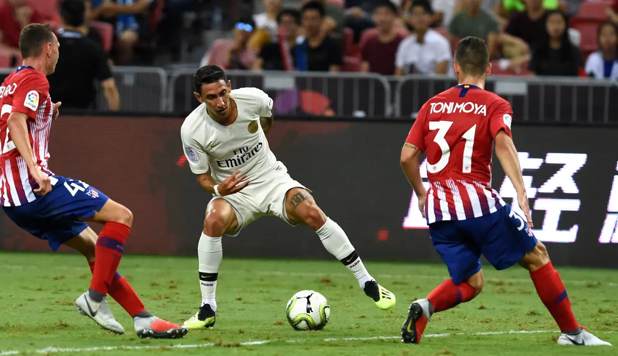Penyerang Paris Saint-Germain (PSG), Angel Di Maria, berusaha melewati pemain Atletico Madrid pada laga ICC 2018 di Stadion Nasional Singapura, Senin (30/7/2018). PSG menang 3-2 atas Atletico Madrid. (AFP/Roslan Rahman)