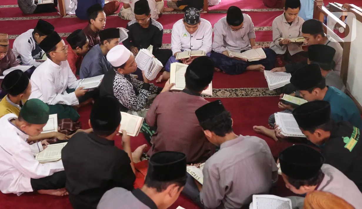 Sejumlah santri membaca Alquran atau bertadarus di pondok pesantren kawasan Tangerang, Senin, (26/4/2021). Bulan Ramdhan banyak dimanfaatkan para santri tersebut untuk mematangkan hafalan Alquran hingga khatam. (Liputan6.com/Angga Yuniar)