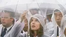 Seorang wanita tampak menggunakan jas hujan dan mpayung saat peringatan 69 tahun tragedi bom Hiroshima di Peace Memorial Park, Rabu (6/8/14). (REUTERS/Kyodo)