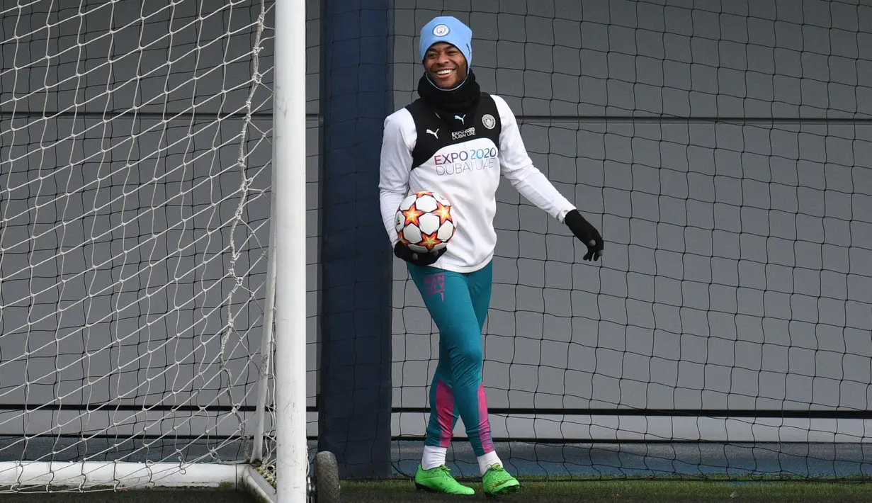 Gelandang Manchester City, Raheem Sterling bereaksi saat ia menghadiri sesi latihan tim di City Football Academy di Manchester, barat laut Inggris (8/3/2022). City akan bertanding melawan Sporting CP pada babak 16 besar Liga Champions. (AFP/Oli Scarff)