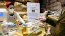 Penjaga toko menjual 'roti untuk perdamaian' yang dibuat Matteo Cunsolo di Parabiago dekat Milan di Italia utara (17/3/2022). Cunsolo juga memberikan kata 'perdamaian' disemprotkan mentega di sisi-sisinya sebagai solidaritas dengan negara yang dilanda perang itu. (AP Photo/Luca Bruno)