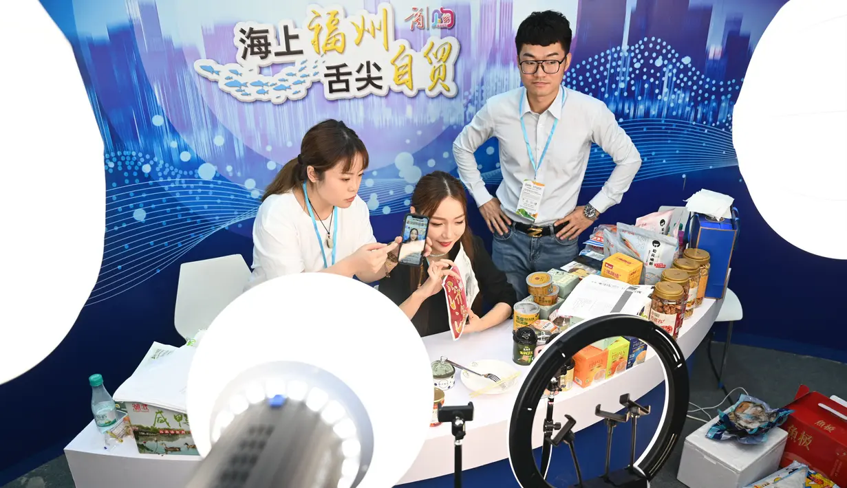 Seorang staf memperkenalkan makanan khas daerah melalui livestreaming di Pameran Hidangan Bahari dan Perikanan Internasional China (Fuzhou) di Fuzhou, Provinsi Fujian, China, 4 September 2020. Pameran tahun ini diadakan secara daring dan luring. (Xinhua/Lin Shanchuan)