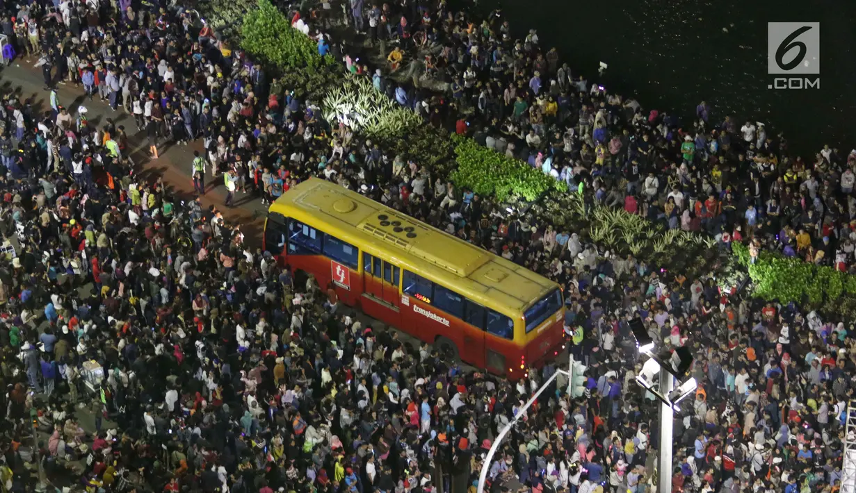 Ribuan warga memadati kawasan Bundaran HI pada malam pergantian tahun baru di Jakarta, Senin (1/1/2018). Bundaran HI menjadi salah satu pusat ibukota Jakarta untuk manyaksikan malam pergantian tahun. (Liputan6.com/Angga Yuniar)