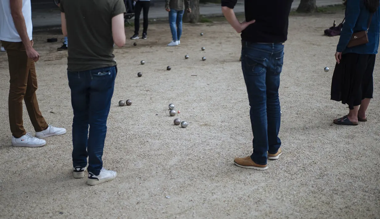 Orang-orang bermain petanque di Paris, Prancis, Sabtu (5/6/2021). Jumlah kasus baru COVID-19 di Prancis semakin menurun. (AP Photo/Lewis Joly)