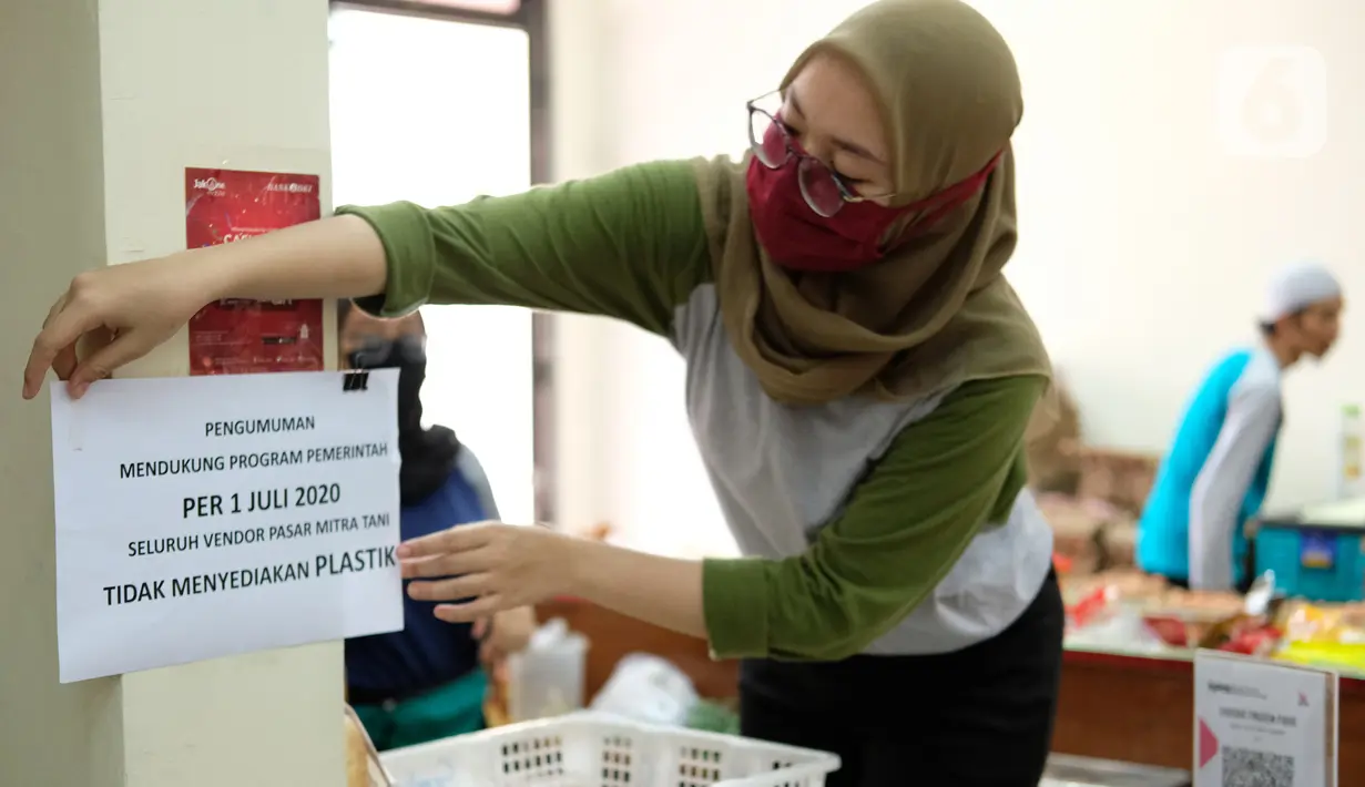 Petugas menempel pengumuman terkait penggunaan kantong plastik di Pasar Mitra Tani, Jakarta, Selasa (30/6/2020). Pasar Mitra Tani akan melarang penggunaan kantong plastik sekali pakai untuk seluruh vendor dan konsumen pasar mulai Rabu, 1 Juli 2020. (Liputan6.com/Angga Yuniar)