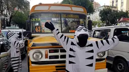 Warga berpakaian seperti zebra menyapa pengendara saat program pendidikan di jalan di La Paz, Bolivia,(5/12). Tujuan aksi ini menyadarkan prilaku pengendara dan pejalan kaki untuk mematuhi rambu lalu lintas seperti zebra cross. (REUTERS/David Mercado)