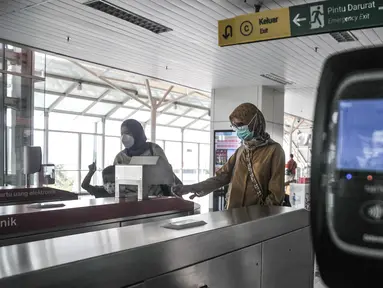 Calon penumpang Light Rail Transit (LRT) Jakarta memindai kartu saat memasuki Stasiun Velodrome, Rawamangun, Kamis (24/3/2022). Pemprov mengusulkan kepada DPRD DKI Jakarta terkait penetapan tarif integrasi transportasi Transjakarta, MRT dan LRT Jakarta sebesar Rp 10.000 (merdeka.com/Iqbal S Nugroho)