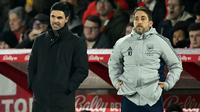 Manajer Arsenal asal Spanyol, Mikel Arteta (kiri) dan pelatih teknik Arsenal asal Prancis, Nicolas Jover, menyaksikan para pemain dari pinggir lapangan selama pertandingan Liga Inggris antara Nottingham Forest dan Arsenal di The City Ground di Nottingham, Inggris tengah, pada 17 Januari 2026. (JUSTIN TALLIS/AFP)