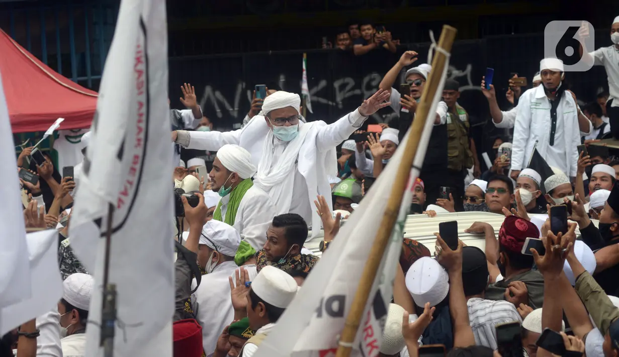 Rizieq Shihab menyapa massa pendukungnya saat tiba di kediamannya di Jalan Petamburan, Jakarta, Selasa (10/11/2020). Rizieq Shihab tiba di kediamannya usai pulang dari Arab Saudi. (merdeka.com/Imam Buhori)