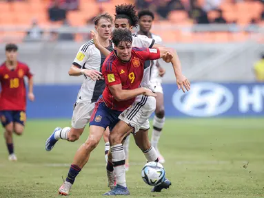 Pemain Timnas Jerman U-17, Paris David Odogu (tengah),&nbsp;berusaha menghalau pergerakan pemain Spanyol U-17, Marc Guiu dalam pertandingan perempat final Piala Dunia U-17 2023 yang berlangsung di Jakarta International Stadium, Jumat (24/11/2023). (Bola.com/Bagaskara Lazuardi)