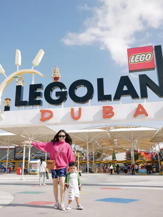 Berpose di depan Legoland Dubai, Momo kembali tampil stylish saat momong sang buah hati. Ia memilih mengenakan legging pendek bermotif abstrak berwarna biru-hitam, dipadunya dengan turtleneck sweater berwarna fuchsia, dan sneakers, serta sunglasses. Foto: Instagram.
