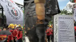 Puluhan elemen buruh menggeruduk gedung DPR RI, Jakarta, Selasa (10/1/2023). Massa juga menggantung banner besar bertuliskan "cabut Perppu No 2 Tahun 2022" di pintu utama Gedung DPR. (Liputan6.com/Faizal Fanani)