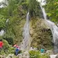 Sejumlah wisatawan menikmati air terjun dengan berfoto di Air Terjun Sri Gethuk, Kabupaten Gunungkidul, Yogyakarta, Sabtu (11/11). Wisatawan harus menempuh perjalanan melintasi Sungai Oya sepanjang 400 meter. (Liputan6.com/Herman Zakharia)