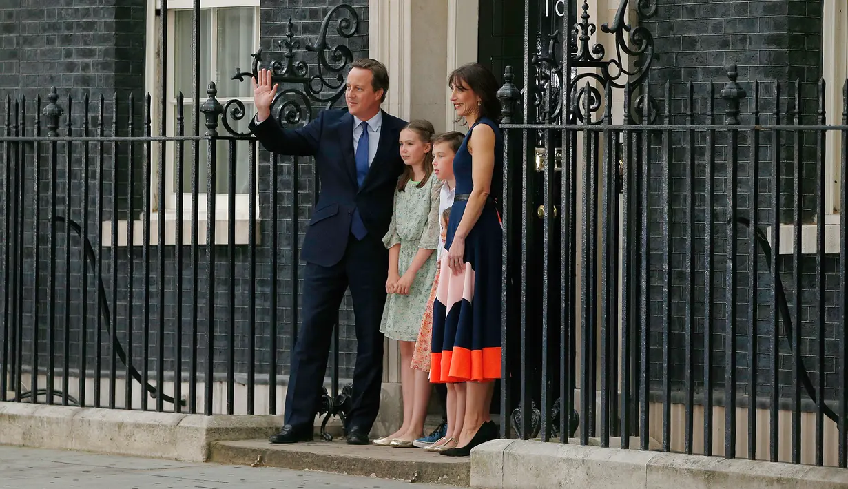 David Cameron didampingi istri Samantha dan ketiga anaknya, melambaikan saat akan meninggalkan kantornya, 10 Downing Street, London, Rabu (13/7). David Cameron mundur dari jabatannya sebagai PM Inggris pasca referendum Uni Eropa. (AFP PHOTO/Adrian DENNIS)