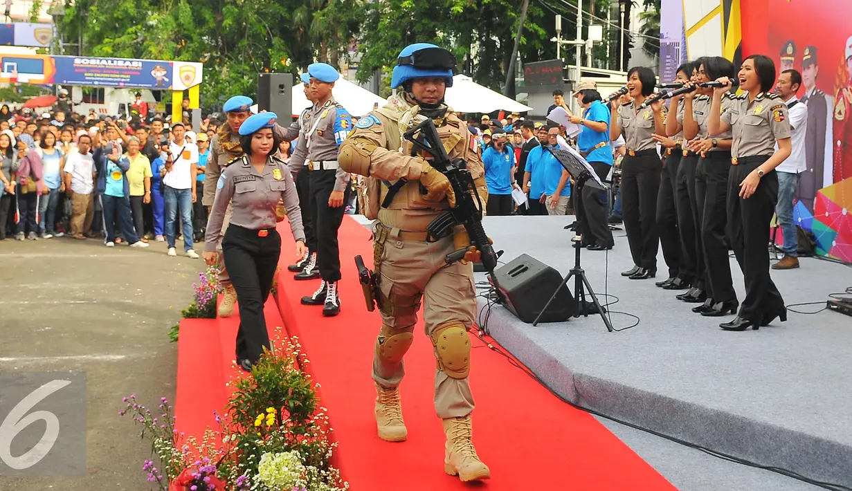 Anggota POLRI mengenakan seragam dan senjata lengkap berjalan diatas panggung saat parade busana di Bunderan HI, Jakarta (5/2). Kegiatan ini dalam rangka mensosialisasikan penerimaan anggota POLRI kepada masyarakat luas. (Liputan6.com/Angga Yuniar)