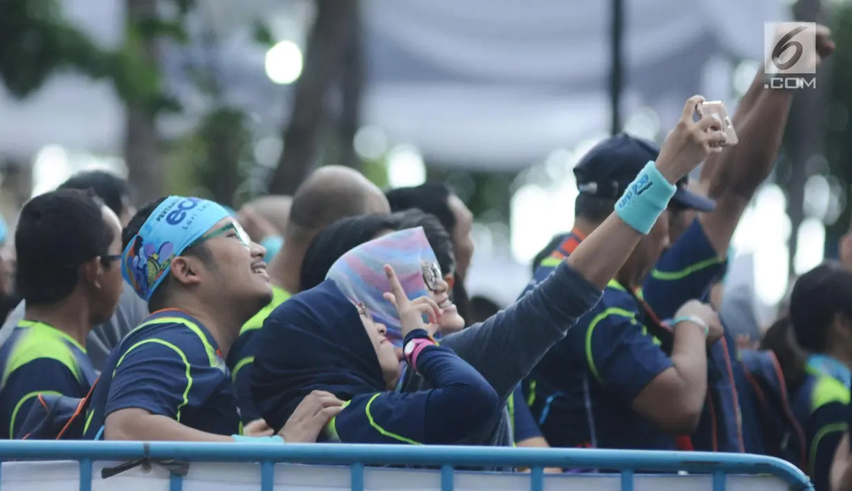 Pelari berswafoto jelang start lomba Pertamina Eco Run 2017 di Pantai Karnaval Ancol, Jakarta, Sabtu (16/12). Pertamina Eco Run 2017 diikuti ribuan pelari dari tiga kategori, yakni master, umum dan pelajar. (Liputan6.com/Helmi Fithriansyah)
