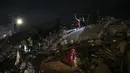 Tim penyelamat mencari orang-orang di sebuah bangunan yang hancur, di Adiyaman, tenggara Turki, Rabu, 8 Februari 2023. Dengan harapan menemukan korban selamat memudar, tim penyelamat yang membentang di Turki dan Suriah pada Rabu masih mencari tanda-tanda kehidupan di antara puing-puing ribuan bangunan yang roboh akibat gempa paling mematikan di dunia dalam lebih dari satu dekade. (AP Photo/Emrah Gurel)