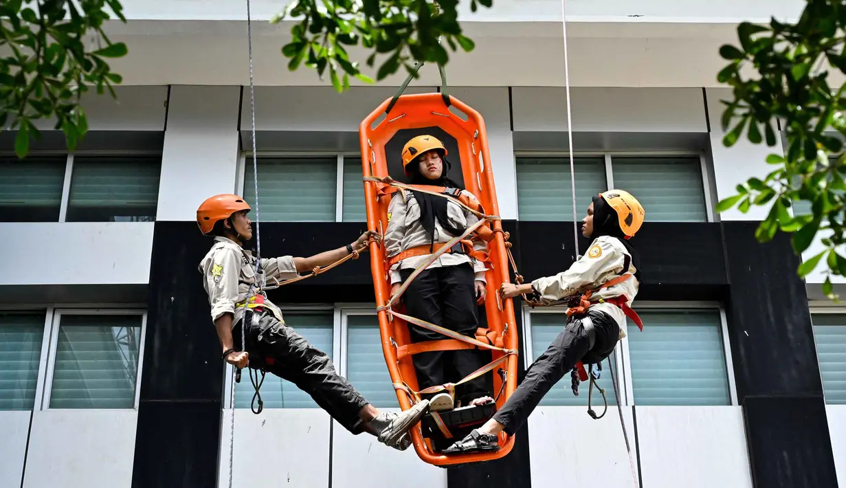 Mahasiswa mengikuti simulasi Vertical Rescue atau evakuasi vertikal selama latihan gempa bumi dan bencana di Universitas Syiah Kuala, Banda Aceh pada Selasa 21 Oktober 2025. (CHAIDEER MAHYUDDIN/AFP)
