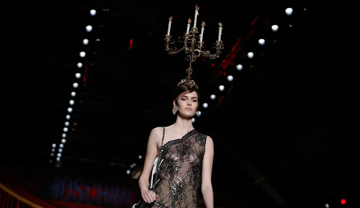 Model mengenakan busana rancangan Moschino dengan hiasan kepala berbentuk tempat lilin dalam Milan Fashion Week Autumn/Winter 2017 di Milan, Italia, (23/2). (AFP Photo / Marco Bertorello)