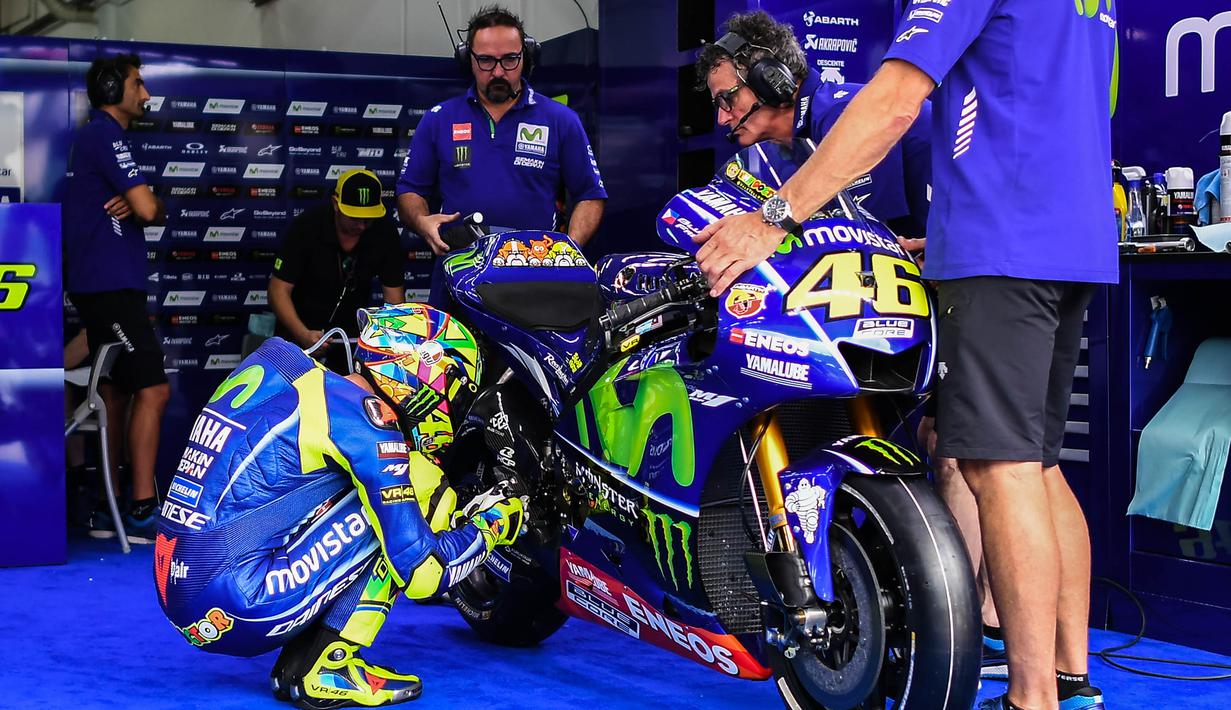 Pebalap Movistar Yamaha, Valentino Rossi, mengecek kondisi motor saat sesi latihan kedua jelang GP Malaysia di Sirkuit Sepang, Jumat (27/10/2017). Pada sesi ini pebalap Italia itu berada pada posisi keenam dengan waktu 13,071 detik. (AFP/Mohd RASFAN)
