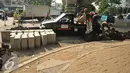 Pekerja tengah mempersiapkan meterial untuk membuat trotoar di Tanah Abang, Jakarta, Senin (18/7). Pemprov DKI tengah berupaya membuat trotoar yang ramah bagi penyandang disabilitas. (Liputan6.com/Gempur M Surya)