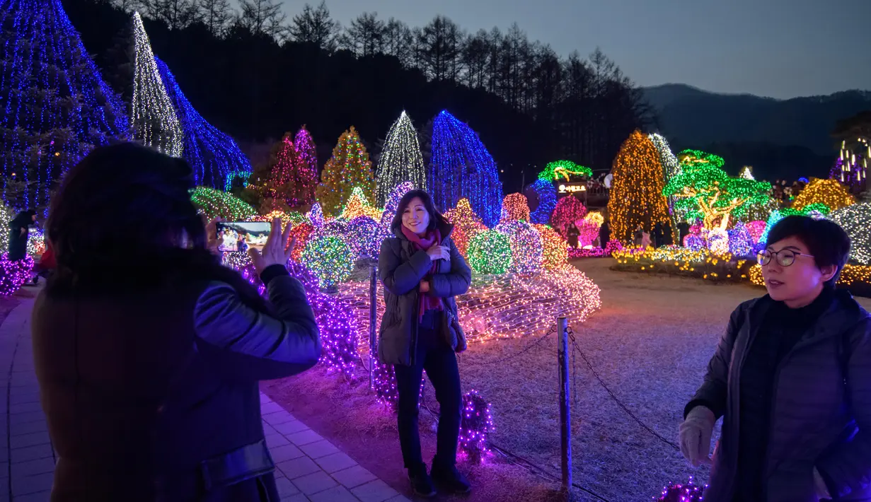Gambar yang diambil 11 Januari 2020, pengunjung melihat tampilan beragam kerlip lampu di Garden of Morning Calm, sebelah timur Seoul di distrik Gapyeong, Korea Selatan. Festival cahaya tahunan tersebut dinikmati saat musim dingin, Desember sampai akhir bulan Maret. (Ed JONES / AFP)