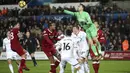 Aksi kiper Swansea City, Lukasz Fabianski menghalau bola dari jangkauan pemain Liverpool pada lanjutan Premier League di Liberty Stadium, Swansea, (22/1/2018). Liverpool kalaj dari Swansea 0-1. (Nick Potts/PA via AP)