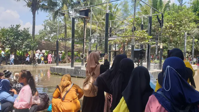 Para pengunjung Taman Satwa Cikembulan Kadungora Garut, nampak tengah menikmati sajian si amang dengan suara khasnya pada libura lebaran Idul Fitri 2023. (Liputan6.com/Jayadi Supriadin)