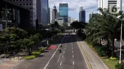 Sejumlah kendaraan melintasi jalan di kawasan Sudirman, Jakarta, Jumat (25/12/2020). Libur Natal dan Tahun Baru 2021 membuat jalanan di beberapa wilayah Ibu Kota terpantau lengang tanpa kemacetan. (Liputan6.com/Angga Yuniar)