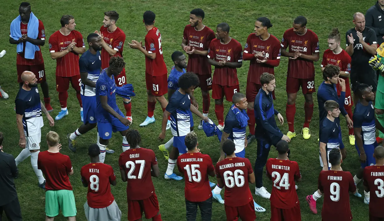 Pemain Chelsea berjalan di depan pemain Liverpool untuk mendapatkan medali setelah pertandingan Piala Super Eropa 2019 di Besiktas Park, di Istanbul (15/8/2019). Chelsea kalah lewat adu penalti atas Liverpool 5-4 (2-2). (AP Photo/Emrah Gurel)
