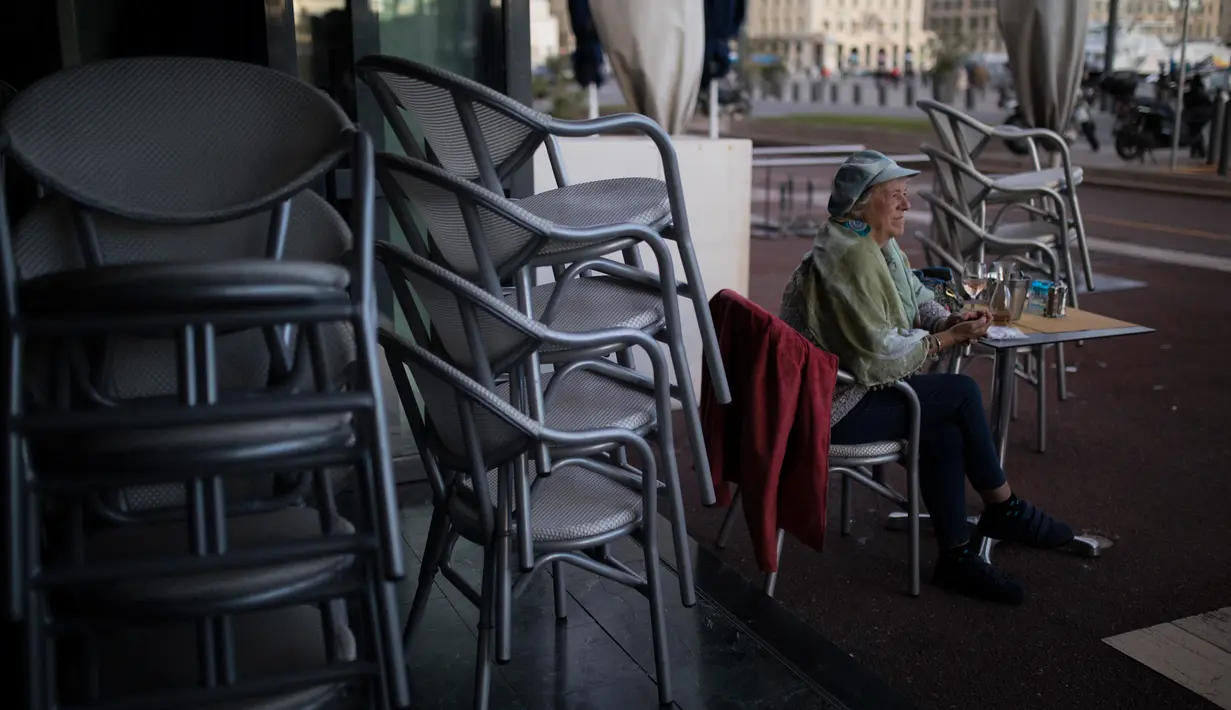 Seorang pelanggan duduk di sebuah restoran yang tutup di Marseille, selatan Prancis, Minggu (27/9/2020). Restoran dan bar di Marseille pada hari Minggu bersiap tutup selama sepekan sebagai bagian dari pembatasan baru baru Covid-19. (AP Photo/Daniel Cole)